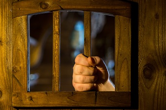 Une main tenant des barreaux en bois